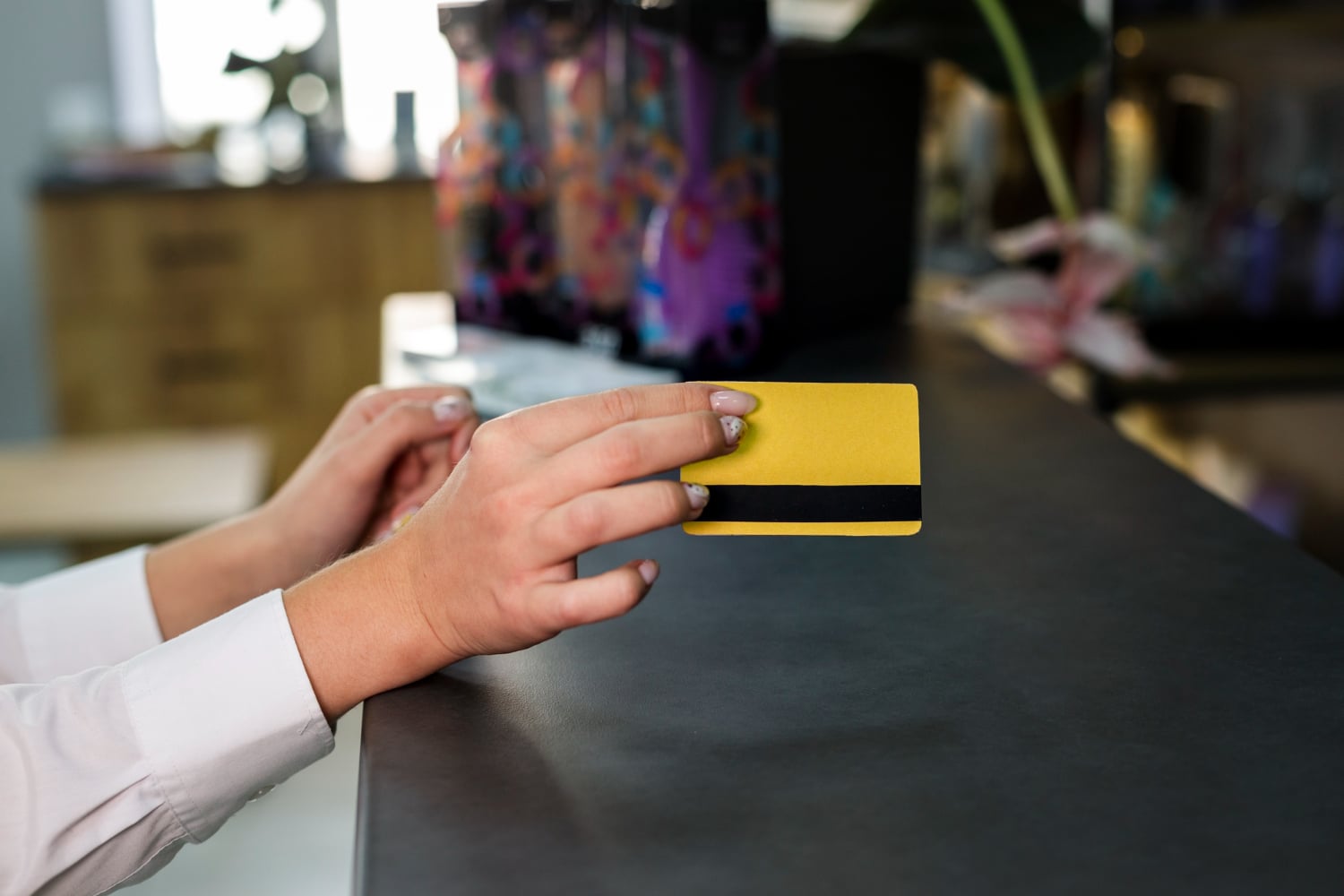 A woman using the American Express Gold Rewards card at the restaurant.