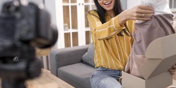 female-vlogger-home-with-camera-unboxing-clothes